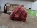 Raw beef on a piece of paper with a kitchen setting in the background