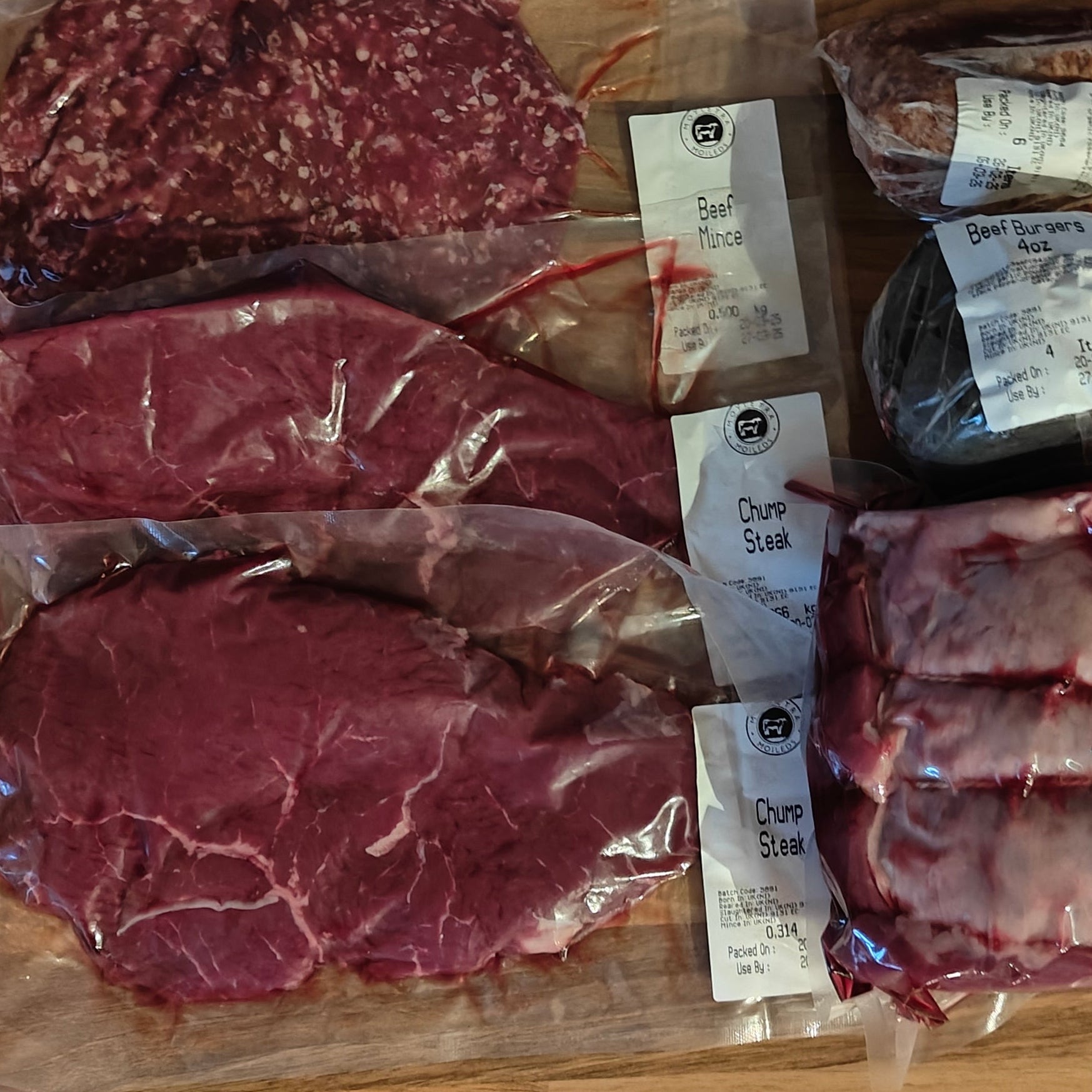 Vacuum packaged meats on a wooden cutting board