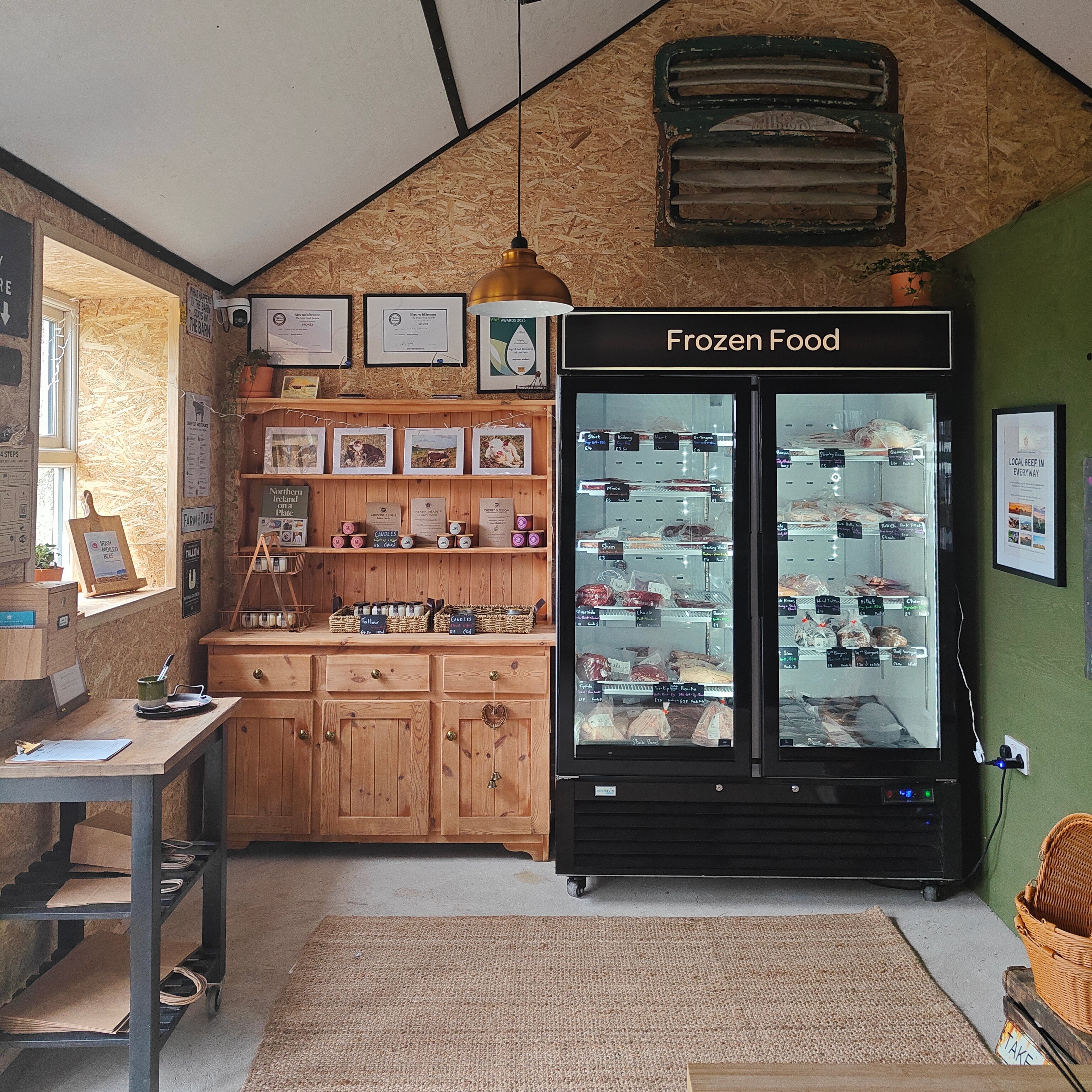 Frozen food display case in a rustic interior setting with wooden walls and shelves.