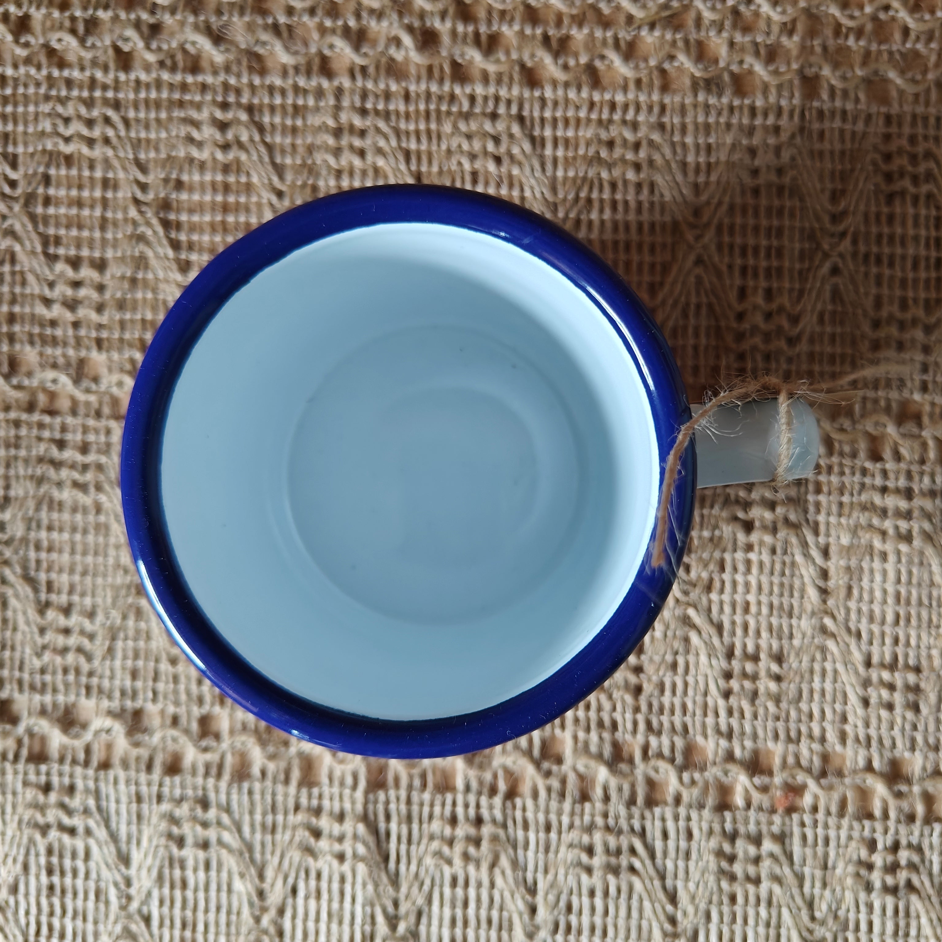 Blue ceramic cup on a textured woven surface