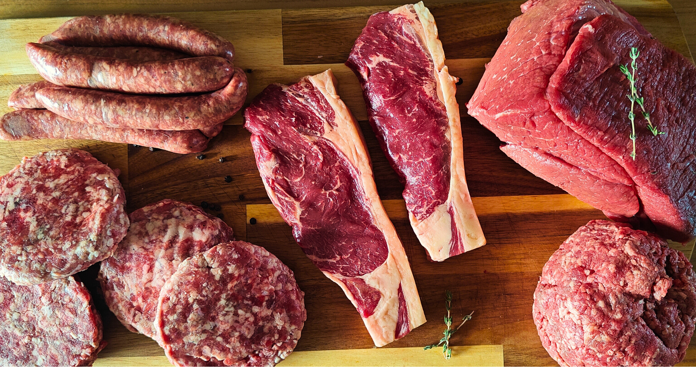 Assorted cuts of raw meat on a wooden cutting board