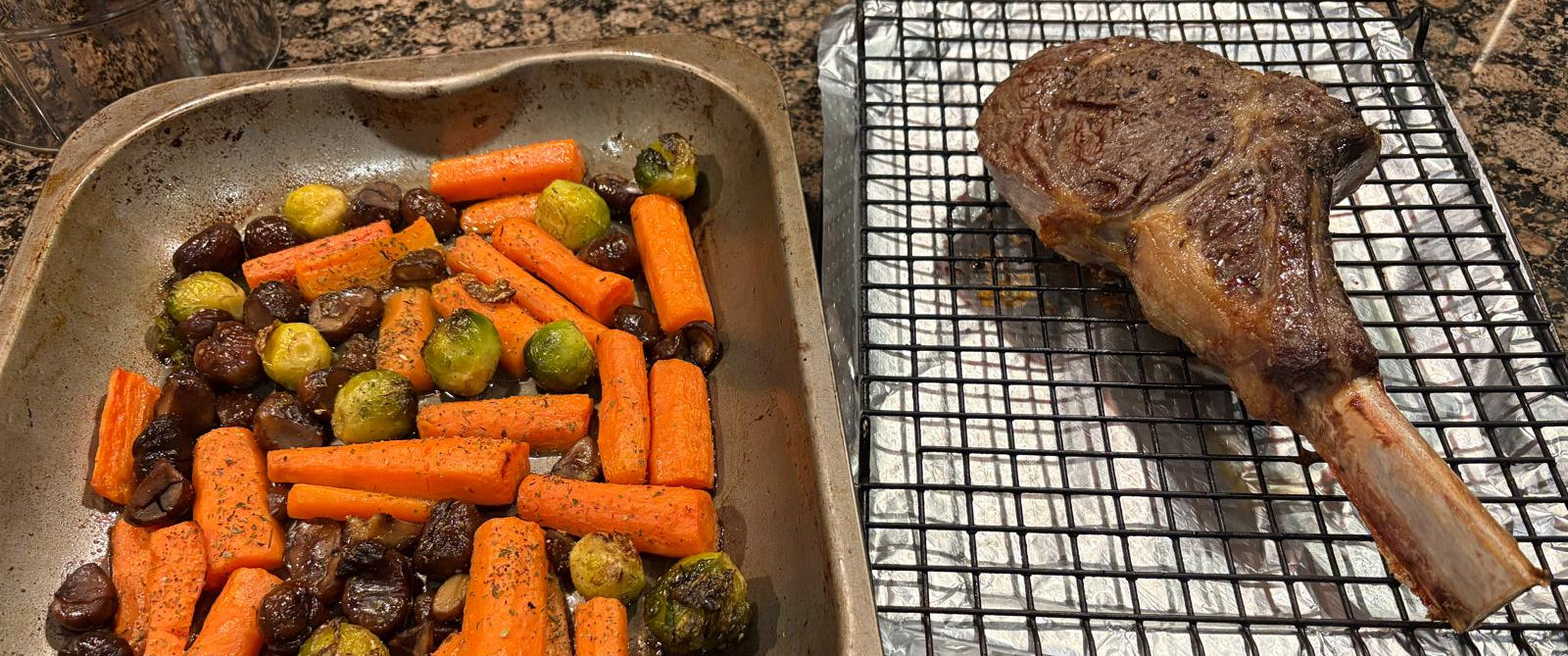 Roasted vegetables and a steak on a grill rack on a kitchen counter.